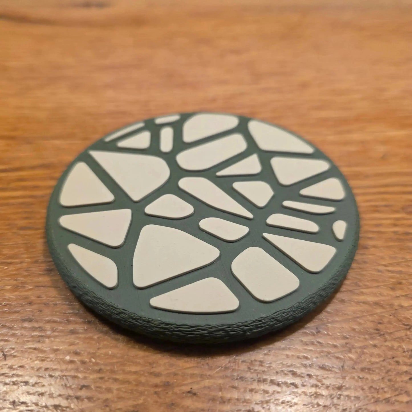 Gros plan sur la structure alvéolaire complexe de type Voronoi d'un dessous de verre , mettant en avant la précision de l'impression 3D.
